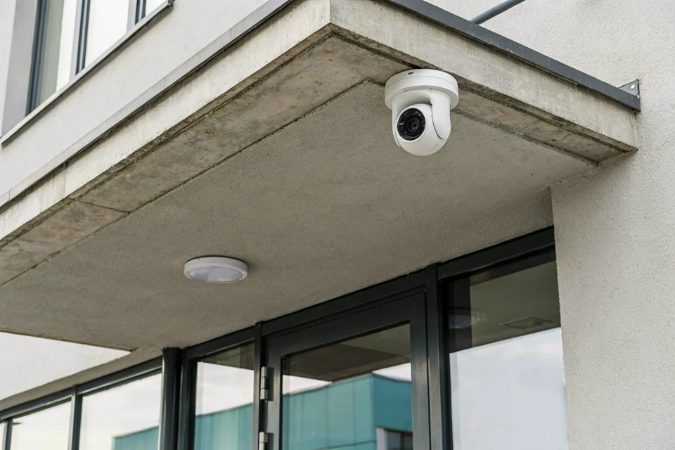 Wizualizacja: kamera monitoringu zamontowana nad wejściem do budynku